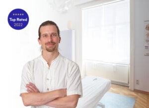 Professioneller Masseur in seiner Praxis mit moderner Einrichtung